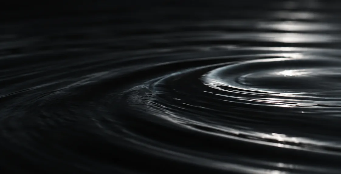Ripples spreading across dark water
